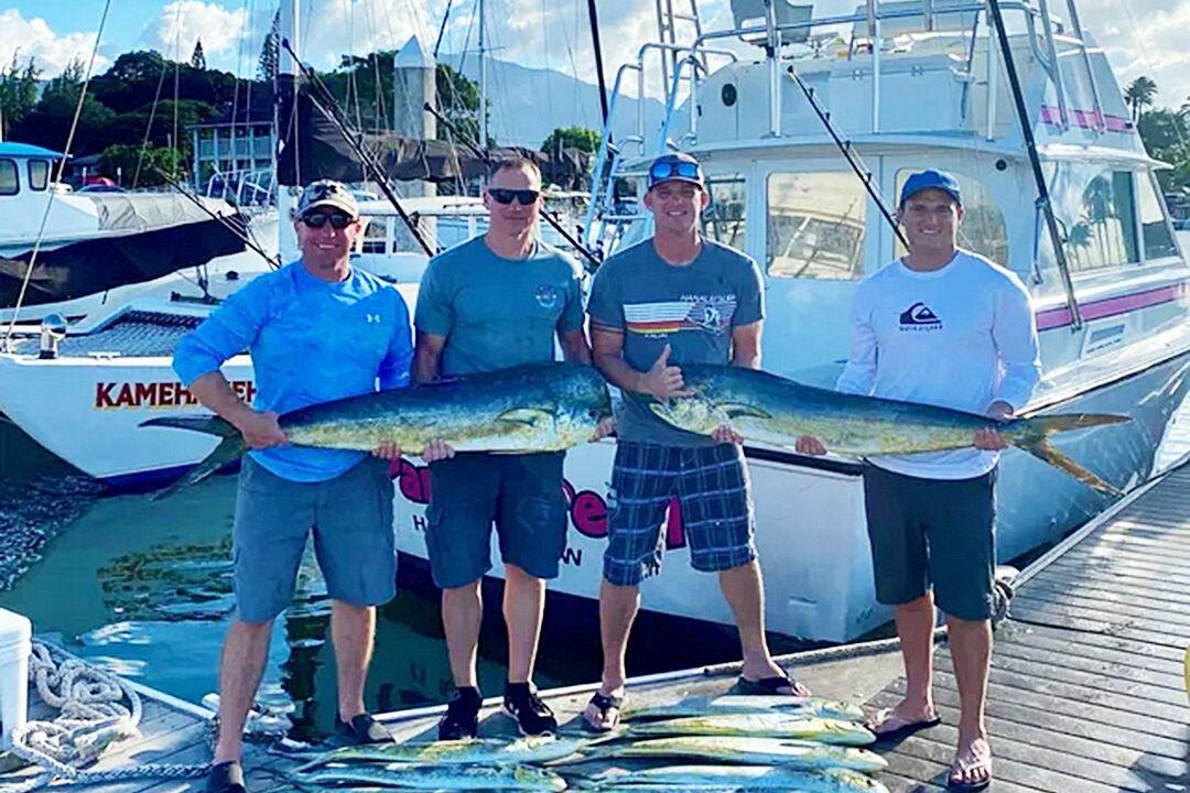 a group of people holding a fish on a boat