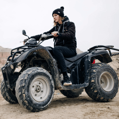 Woman on an ATV in cold conditions demonstrates what to wear on atv tour safely