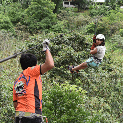 A young girl ziplining while an instructor waits, offering reassurance if is ziplining scary