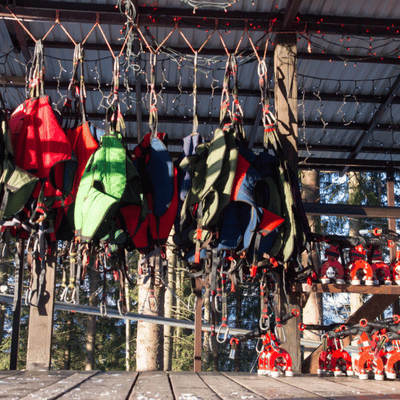 Ziplining safety harnesses hang ready for use, showing equipment that ensures is ziplining safe