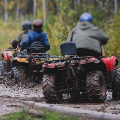 A group of riders blaze muddy trails in sport ATVs, showcasing grip, power, and teamwork