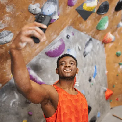 Man taking a selfie after indoor climb, enjoying health benefits of climbing and exercise